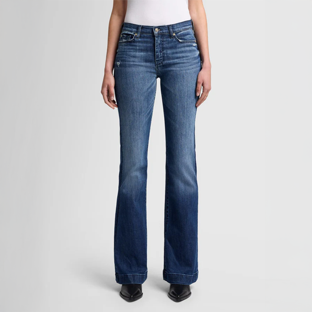Person wearing  DOJO Lake blue flared jeans on a light gray background