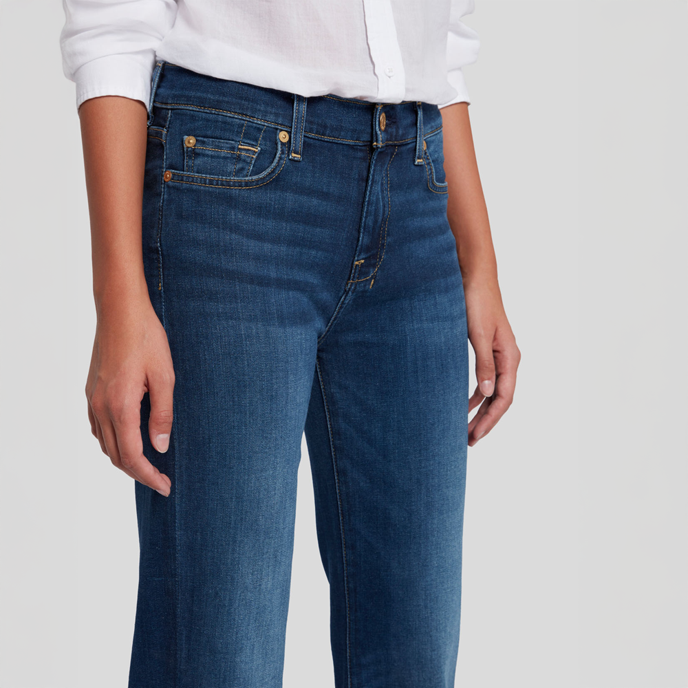 Person wearing  DOJO Melrose blue jeans and a white shirt on a plain background